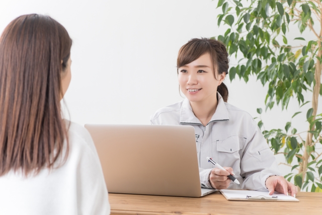 作業服の女性と相談している画像