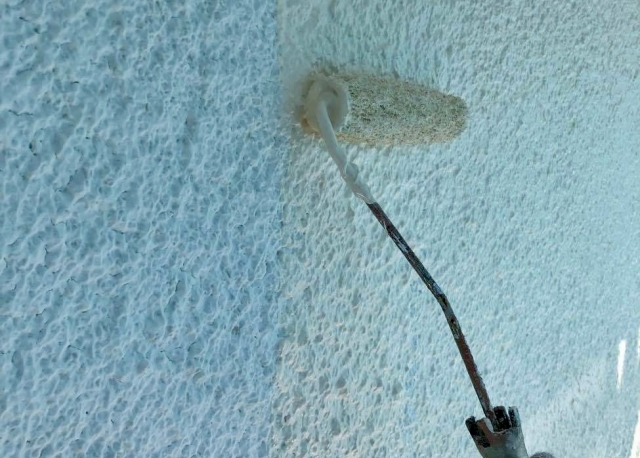 外壁と白いペンキローラー