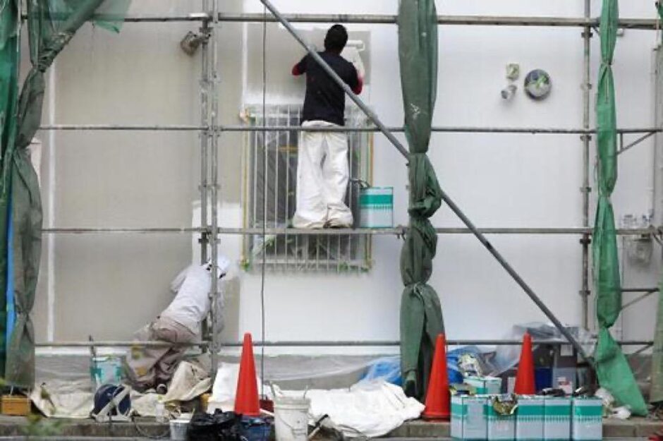外壁の塗り替え施工をする職人